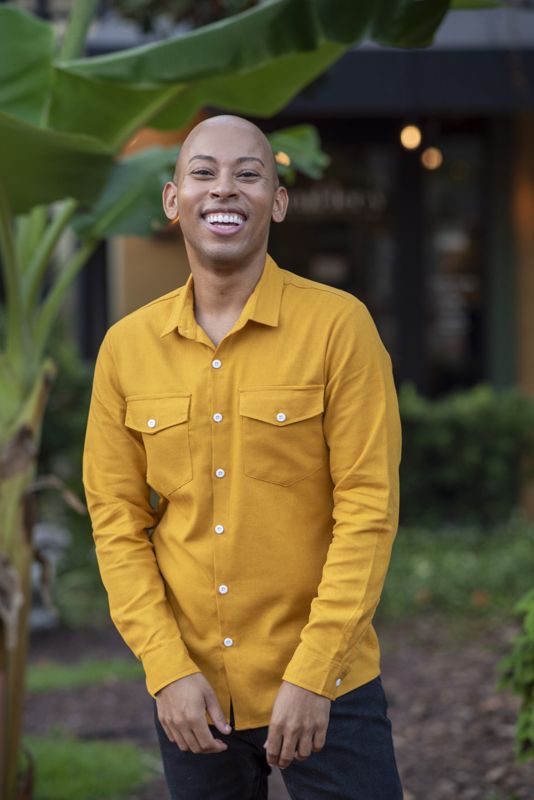 Lemar in a mustard shirt among palms