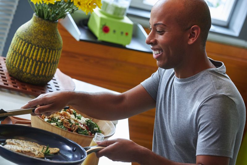 Lemar plating food in a kitchen