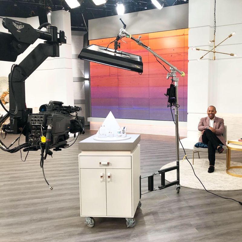 Lemar seated on a television set beside a studio camera