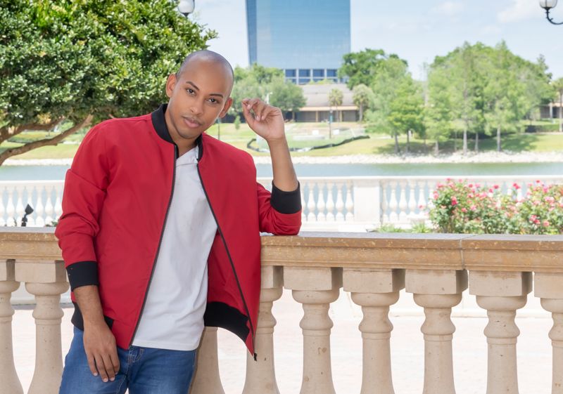 Lemar in a red bomber jacket by the water
