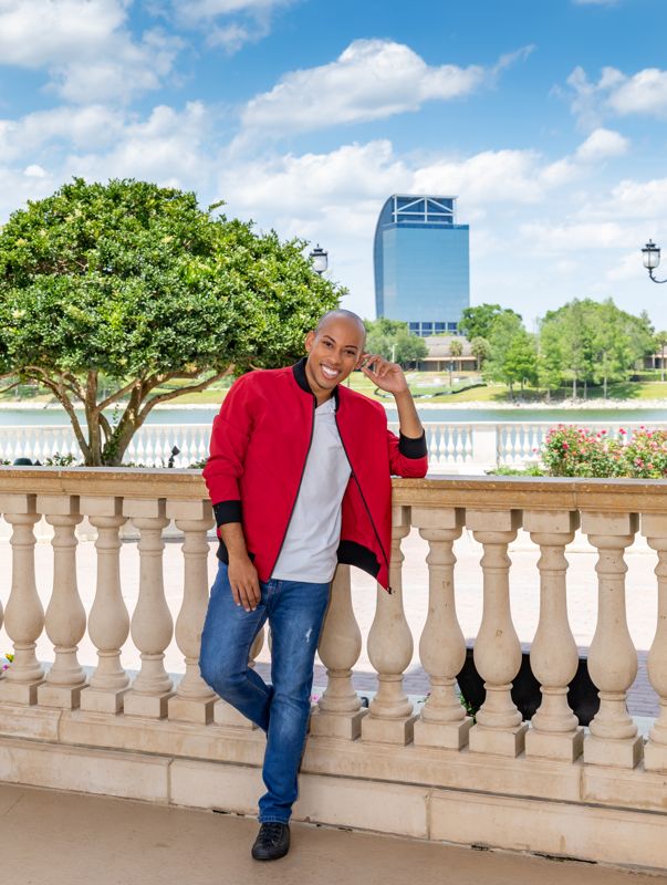 Lemar in a red bomber jacket leaning on a balustrade