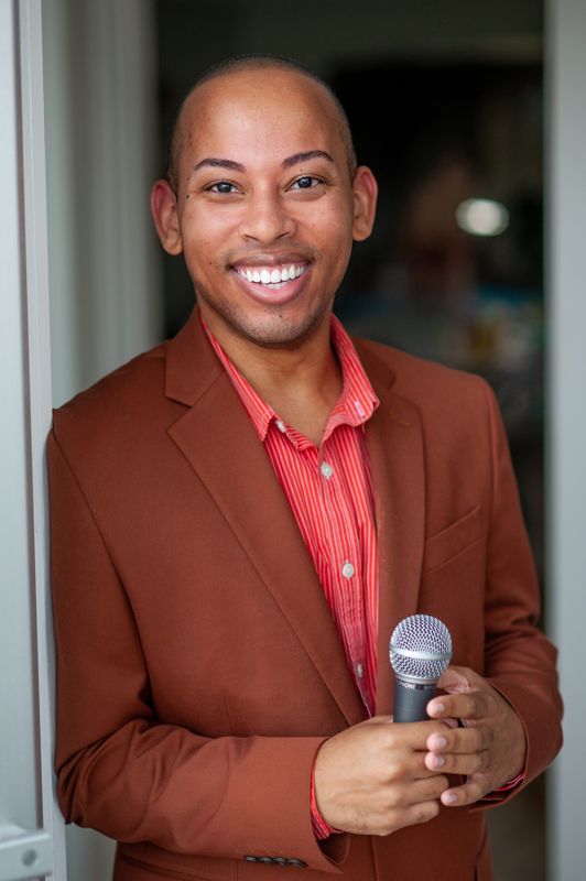 Lemar in a rust jacket holding a microphone
