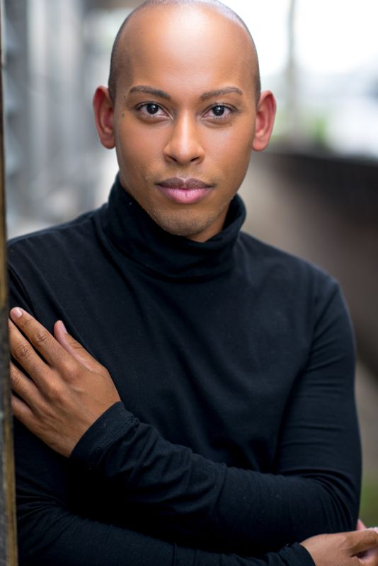 Lemar in a black turtleneck, arms folded