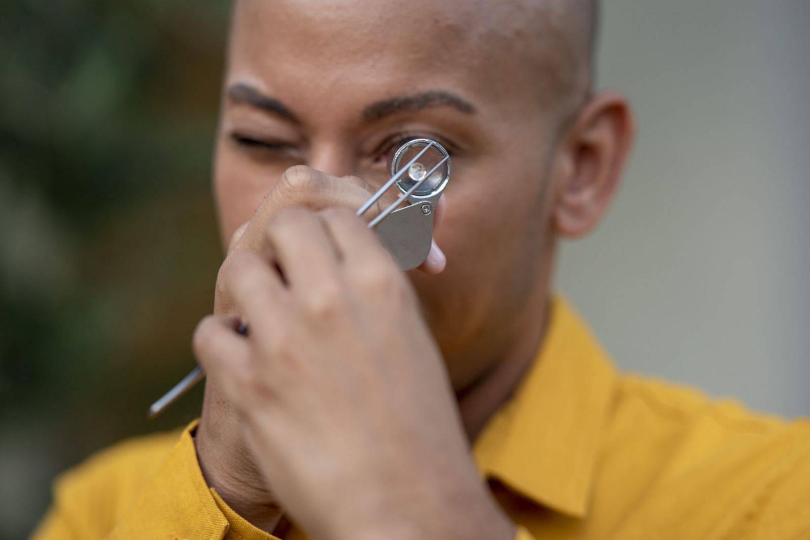 Close-up of Lemar examining a stone through a jeweler's loupe